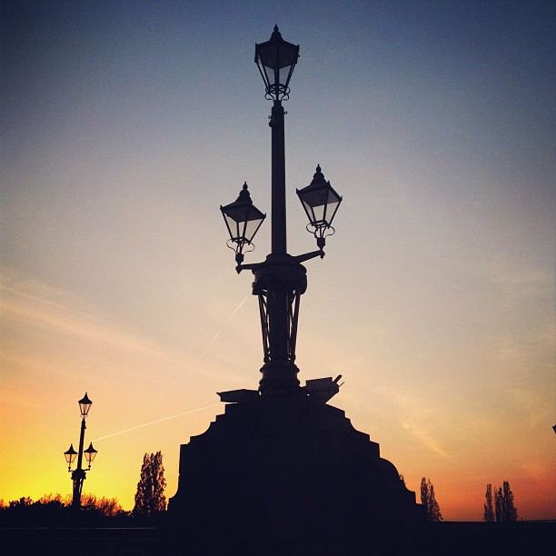 A traditional gas style lamp post against a sunset