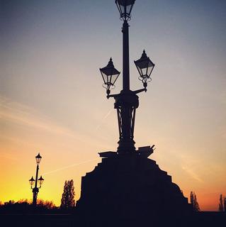 A traditional gas style lamp post against a sunset