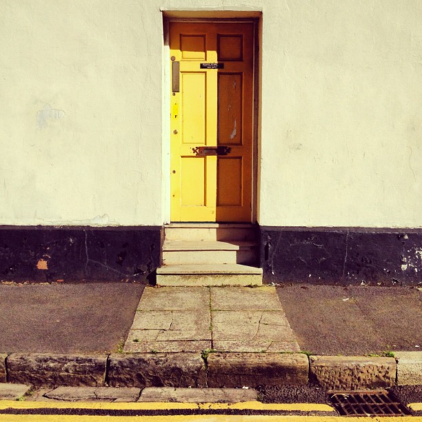 An entrance way to a building with a yellow door.