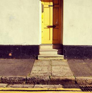 An entrance way to a building with a yellow door.