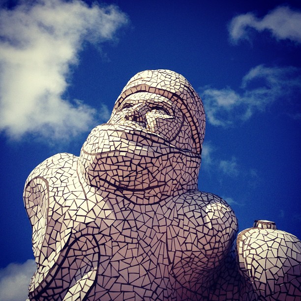 A sculture of a sailor made out of white pieces of tile against the blue sky