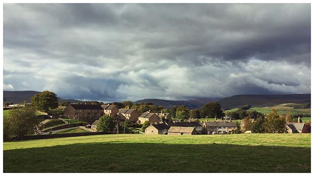 Stormy clouds hover over the houses of the village of Hawes