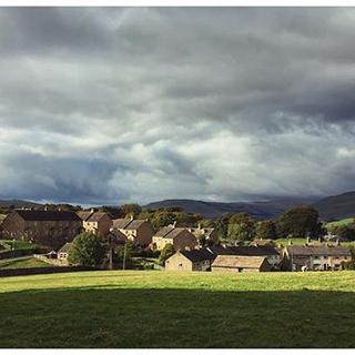 Stormy clouds hover over the houses of the village of Hawes