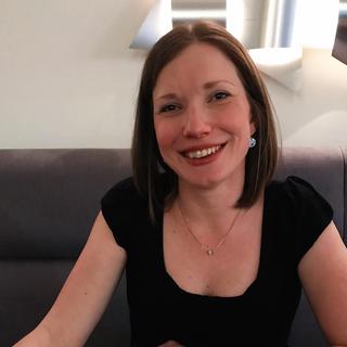 A woman sat at a restaurant table smiling