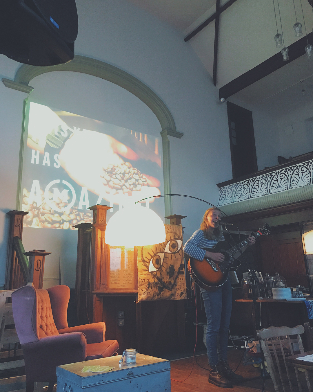 A woman playing a guitar and singing in a church