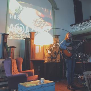 A woman playing a guitar and singing in a church