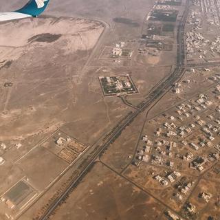 An aerial view of Oman from a plane showing buildings and large expanses of brown land