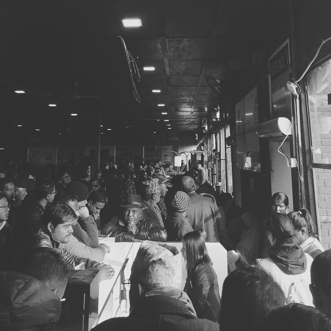 Groups of people waiting for a flight in an airport in black and white