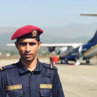 A police man standing in front of a plane