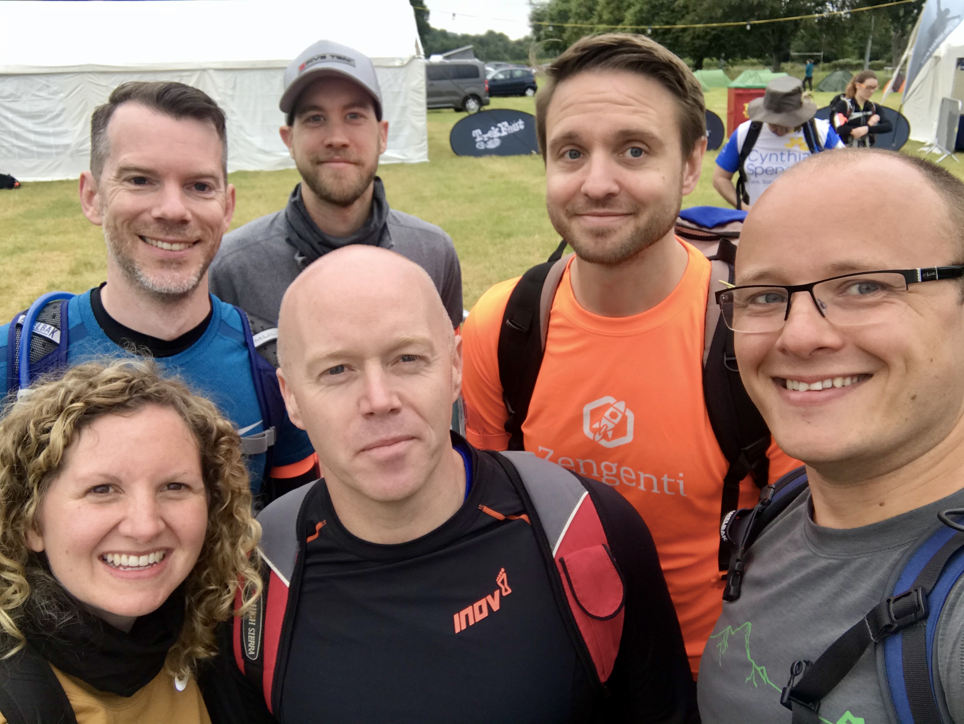 A team of people wearing sports gear about to head off on a long hike.