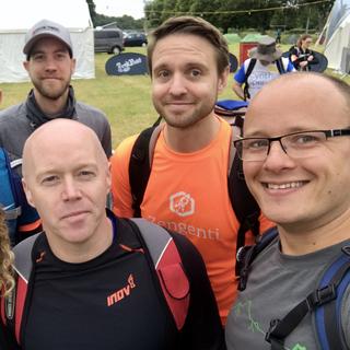 A team of people wearing sports gear about to head off on a long hike.