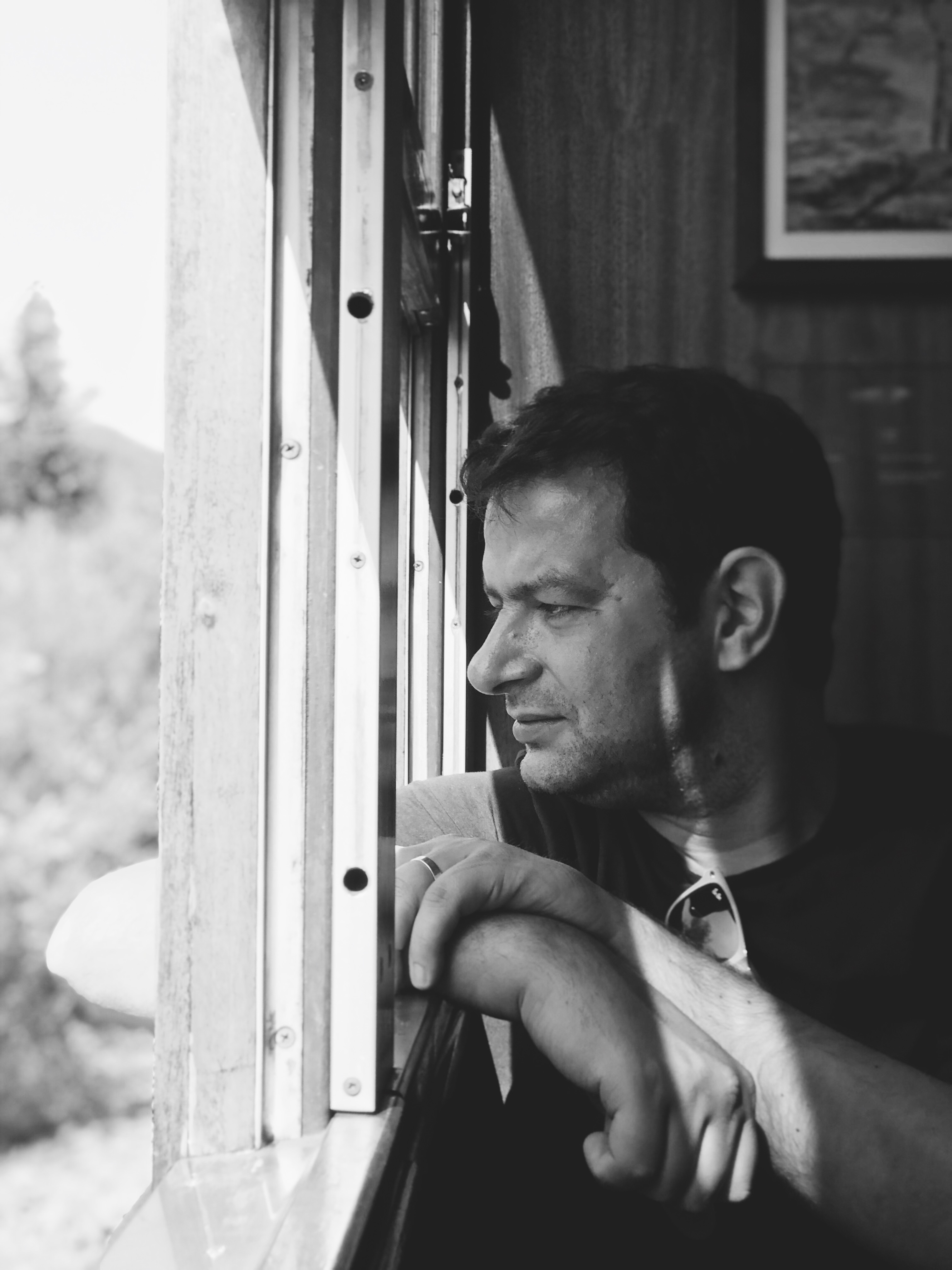 A man sat down looking out of the train window.