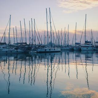 Reflections of boats in a mariener in the early morning light
