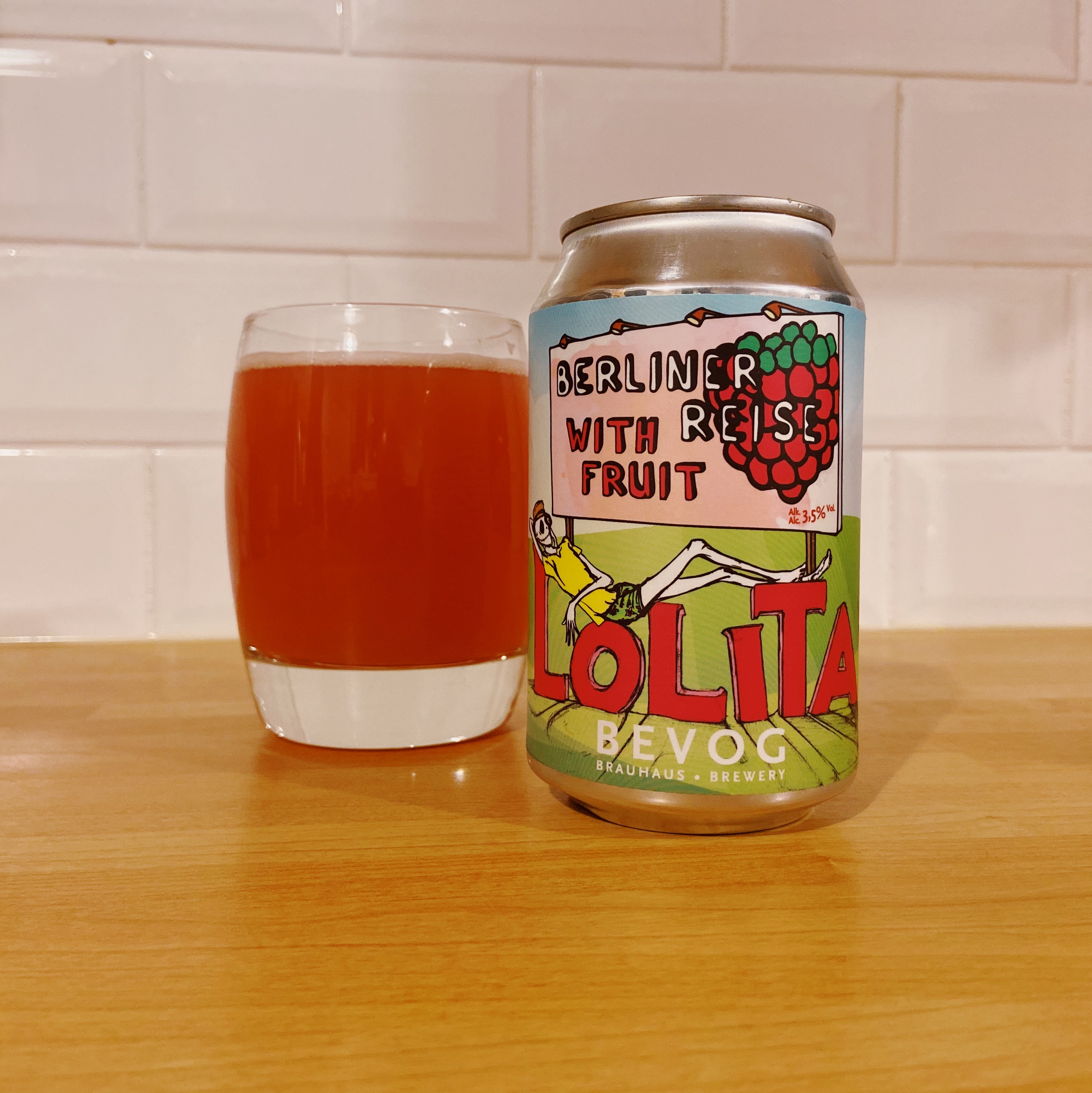 A can of raspberry ale alongside a glass containing a red beer