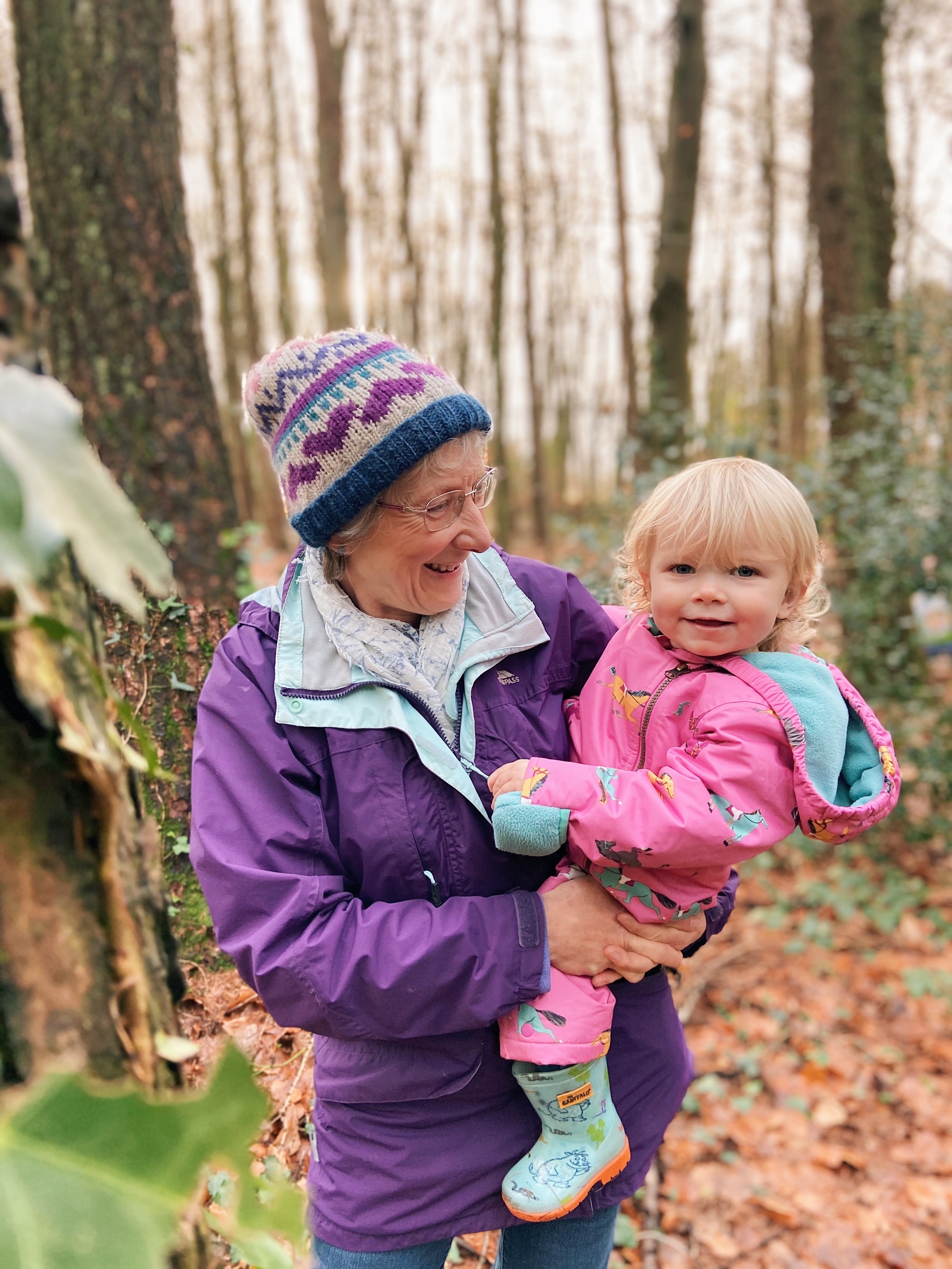 A woman holding a child in some woulds during the winter