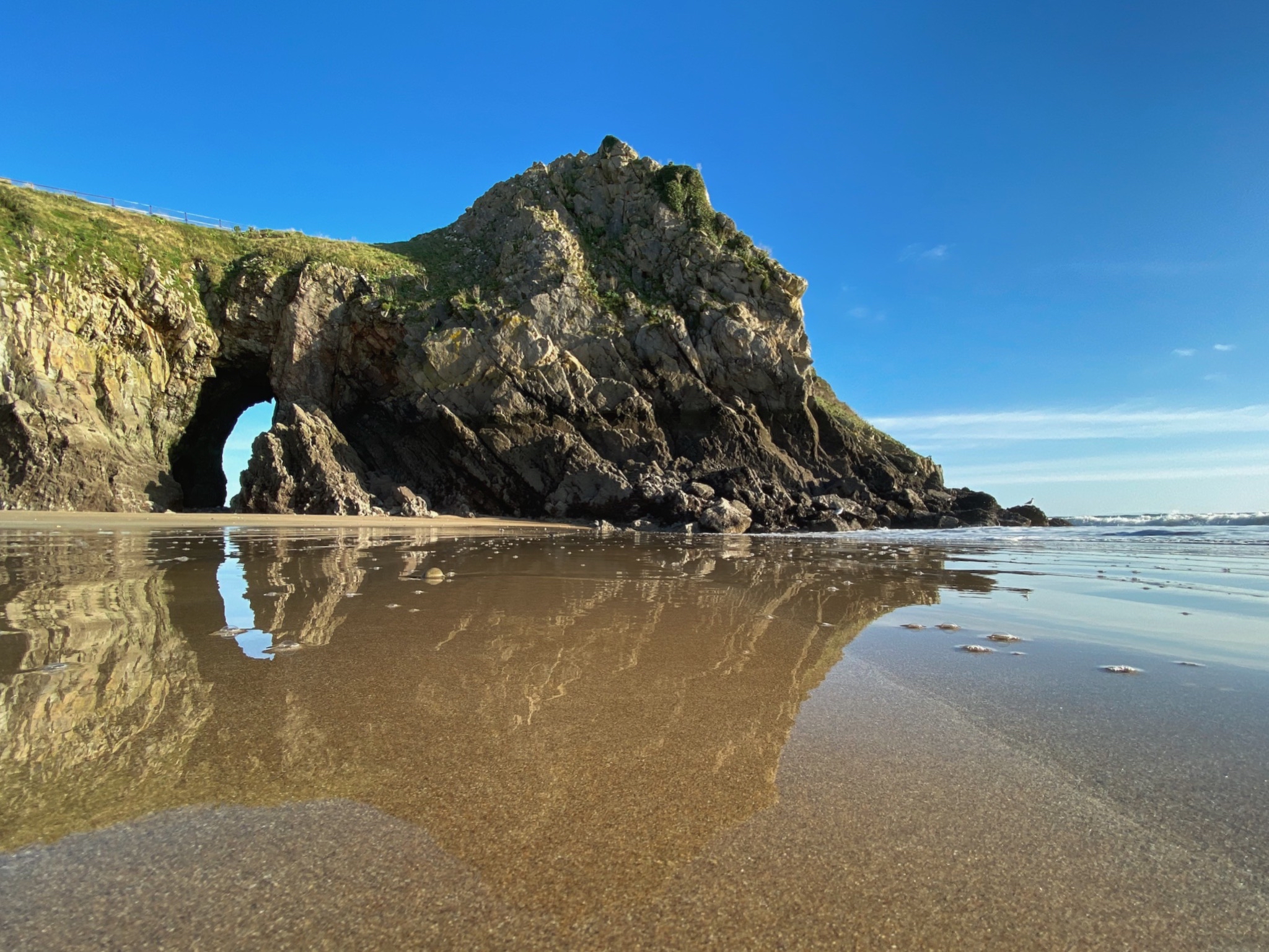 Caldey island reflected in the sand on a beach