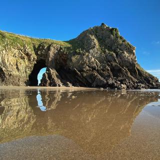 Caldey island reflected in the sand on a beach